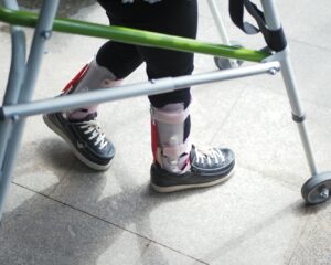 A person standing next to a green walker