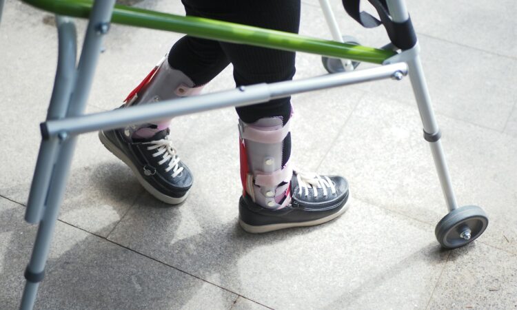 A person standing next to a green walker
