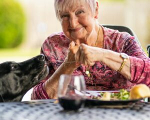woman in pink and gray long sleeve shirt holding clear drinking glass